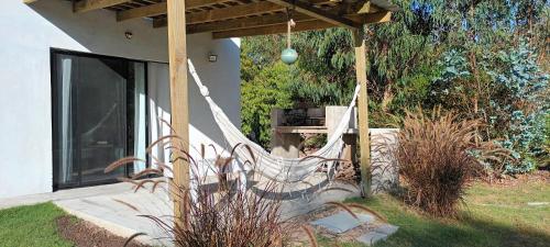 a bench sitting under a pergola on a house at Casa muy luminosa , 2 d in José Ignacio