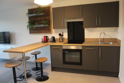 une cuisine avec des placards bruns et un comptoir en bois dans l'établissement Appt avec balcon St Valery / Somme parking privatif 3/4 pers, à Saint-Valery-sur-Somme