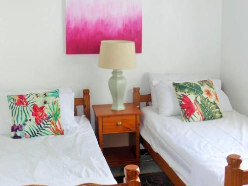 a bedroom with two beds and a lamp on a nightstand at Selen's Apartment in Ti Rocher Micoud Saint Lucia in Micoud