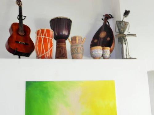 a shelf with a guitar and other items on it at Selen's Apartment in Ti Rocher Micoud Saint Lucia in Micoud