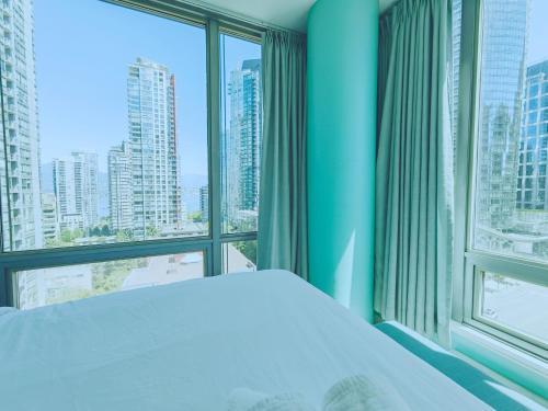 a bedroom with a bed and a large window at Le Canter in Vancouver