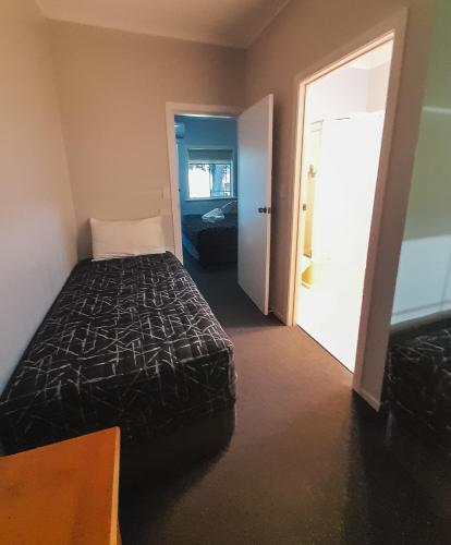 a bedroom with a bed and a door to a room at Golfers Inn in Tenterfield