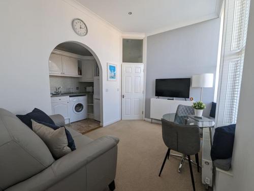 a living room with a couch and a table at 1 Bed Apartment - Sea view in Shanklin