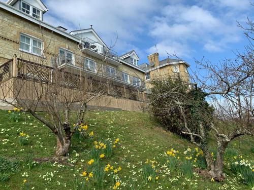 a large building on top of a hill with flowers at 1 Bed Apartment - Sea view in Shanklin