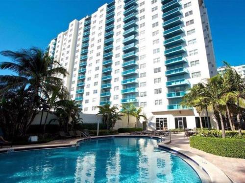 a swimming pool in front of a large building at Beautiful penthouse condo with stunning views of both ocean and city in Hollywood