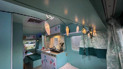 um pequeno quarto com um toucador e luzes num trailer em Ir por ai Arrábida em Azeitao