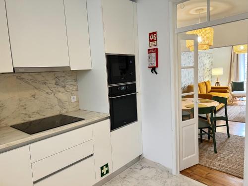 a kitchen with white cabinets and a dining room at Madre de Deus, 5 - Terrace in Évora