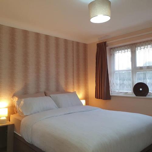 a bedroom with a large white bed and a window at Ideally located contemporary 3 bed spacious house in Wainscot