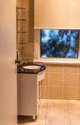 a bathroom with a sink and a window at Golfers Inn in Tenterfield