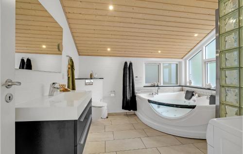 a large bathroom with a tub and a sink at Stunning Home In Fars With Sauna in Hvalpsund