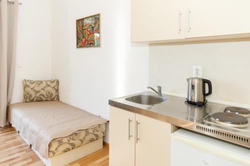 a small kitchen with a sink and a chair at Vila Nikezić in Sutomore