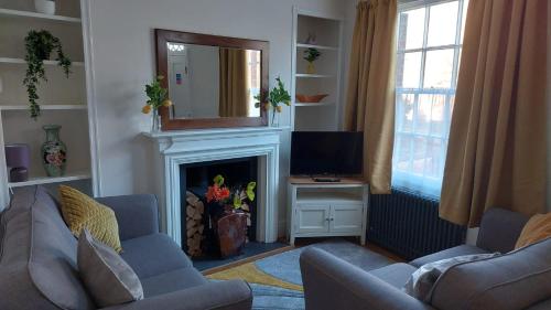 a living room with two couches and a fireplace at Abbey Foregate in Shrewsbury