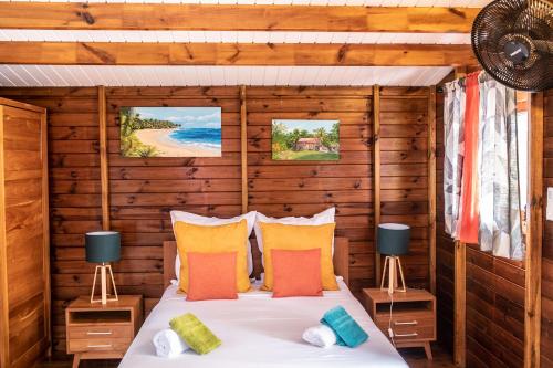1 dormitorio con 1 cama en una cabaña de madera en Domainde de Meilly - M&P Concept Vue mer Jacuzzi OU Piscine, en Saint-Louis