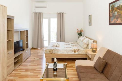 a living room with a bed and a couch at Vila Nikezić in Sutomore