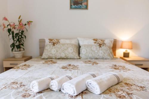 a bedroom with a bed with two towels on it at Vila Nikezić in Sutomore