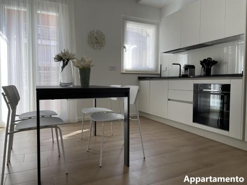 - une cuisine blanche avec une table et des chaises dans l'établissement Casa di Cìì, à Porto San Giorgio