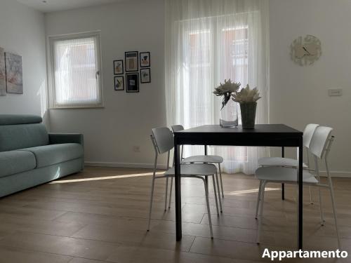 un soggiorno con tavolo, sedie e divano di Casa di Cìì a Porto San Giorgio