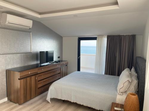 a bedroom with a bed and a television and a window at ONLY ONE Suites & Residences in Antalya