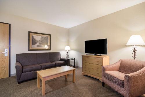 a living room with a couch and a tv and a chair at Best Western Golden Spike Inn & Suites in Hill City