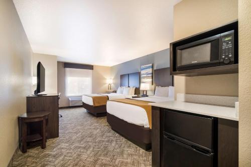 a hotel room with two beds and a flat screen tv at Best Western Golden Spike Inn & Suites in Hill City
