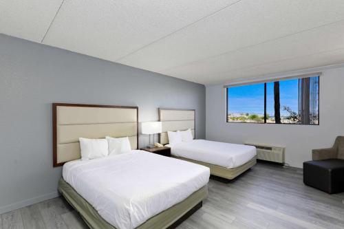 a hotel room with two beds and a window at Studio 6 Suites Lake Havasu City AZ in Lake Havasu City