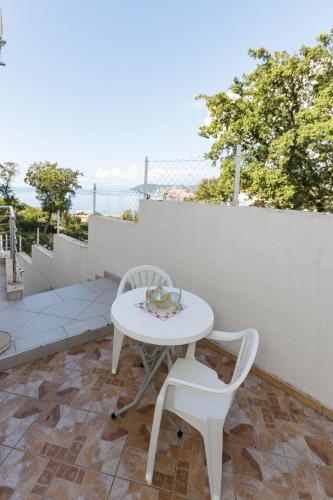 a white table and two chairs on a patio at Vila Nikezić in Sutomore