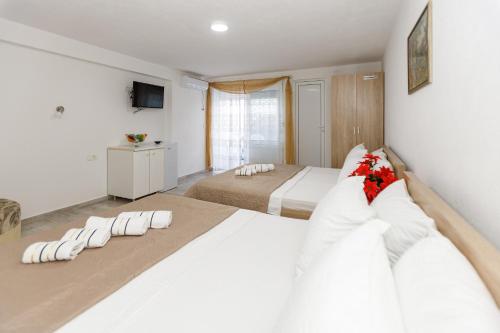 a bedroom with a large white bed with white pillows at Vila Nikezić in Sutomore