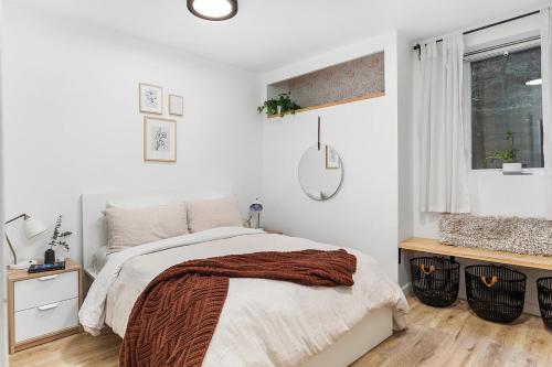 a white bedroom with a bed and a window at The Maple House in Seattle