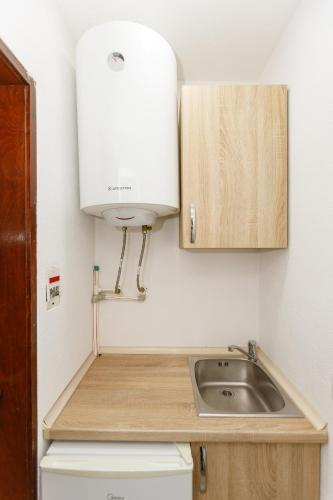 a kitchen with a sink and a white appliance at Vila Nikezić in Sutomore