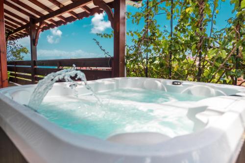 una bañera con agua saliendo de ella en Domainde de Meilly - M&P Concept Vue mer Jacuzzi OU Piscine, en Saint-Louis