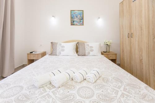 a bedroom with a white bed with three pillows at Vila Nikezić in Sutomore