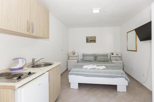 a small bedroom with a bed and a sink at Vila Nikezić in Sutomore