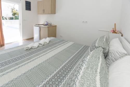 a bedroom with a large bed with towels on it at Vila Nikezić in Sutomore