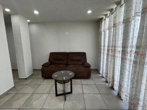 a living room with a brown couch and a table at CASA EL CHALET in Morelia
