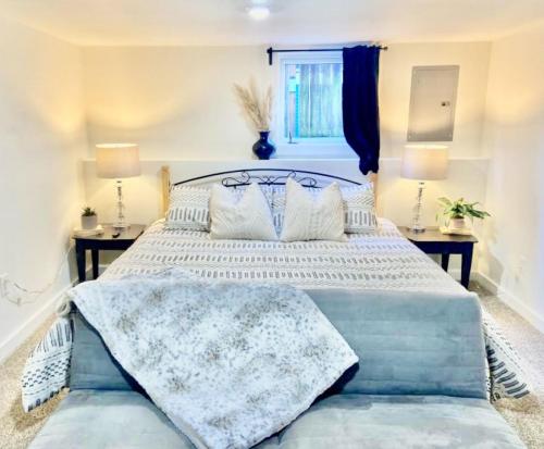 um quarto com uma cama grande com lençóis brancos e almofadas em Downtown Boho Revival Home PNW em Albany