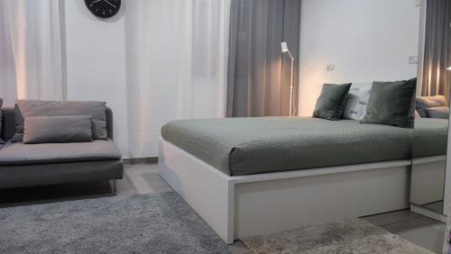 ein Schlafzimmer mit einem Bett und einem Sofa in der Unterkunft Studio Apartment 12 Minutes from Bahai's garden in Haifa