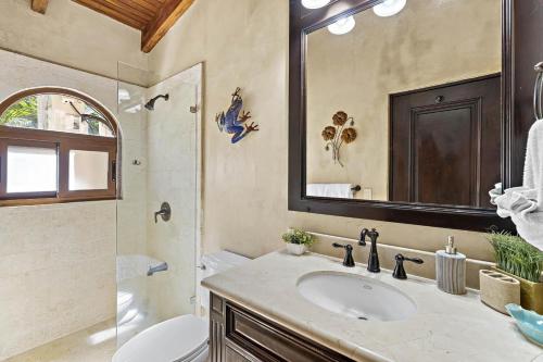 a bathroom with a sink and a toilet and a mirror at Luxury beachfront unit in Flamingo right in front of the waves in Playa Flamingo