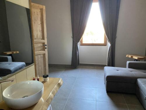 a bathroom with a bowl sink and a couch at Villa Paladini in Montefiascone