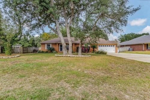 a house with a tree in a yard at New! Close To Beach, Cozy, New beds & Family Friendly in Navarre
