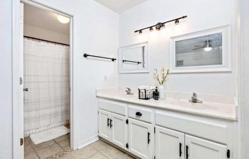 a white bathroom with a sink and a mirror at New! Close To Beach, Cozy, New beds & Family Friendly in Navarre