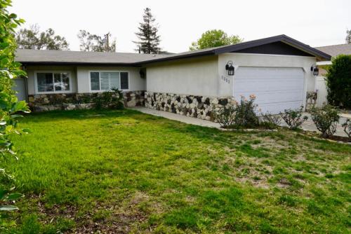 a house with a stone retaining wall and a garage at Cozy Family Hideaway, sleeps 8, 4 tv's yard, shops in Simi Valley