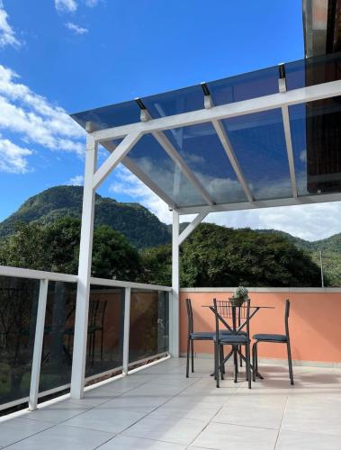 eine Terrasse mit einem Tisch und Stühlen auf dem Balkon in der Unterkunft Loft com linda vista na Rota do Enxaimel in Pomerode
