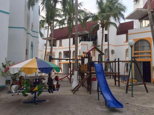 un parque infantil con tobogán y sombrilla en Apartamentos Playa rodadero, en Santa Marta