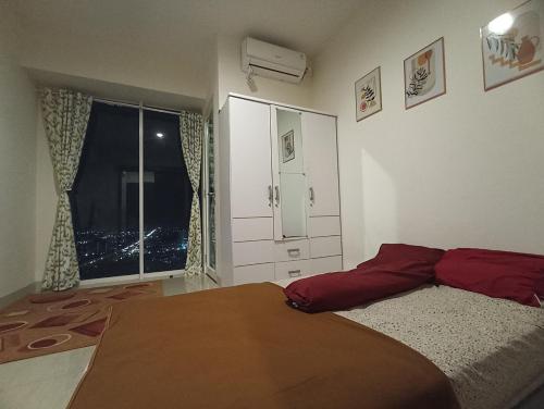 Un dormitorio con una cama grande y una ventana en Grand Kamala Lagoon by Hana Room en Bekasi
