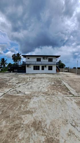 um edifício branco com palmeiras em frente em Meadroad homestay tours & transfers Studio Flat em Suva