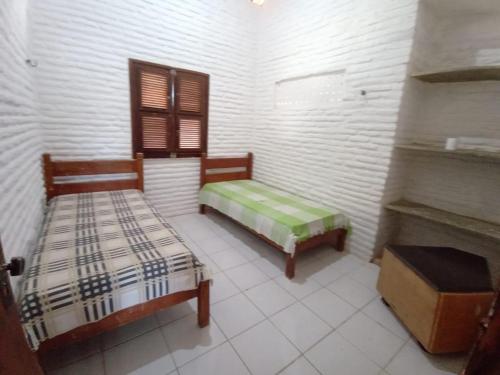 een kamer met 2 bedden en een open haard bij Casa de Praia, na Praia do Presídio in Aquiraz