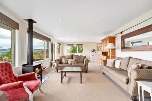 a living room with a couch and a fireplace at Great Lake Getaway - Taupo in Taupo