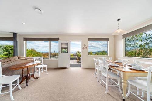 a dining room with a table and chairs and windows at Great Lake Getaway - Taupo in Taupo
