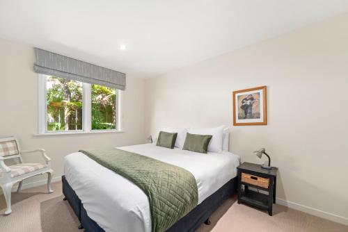 a bedroom with a bed and a chair and a window at Great Lake Getaway - Taupo in Taupo