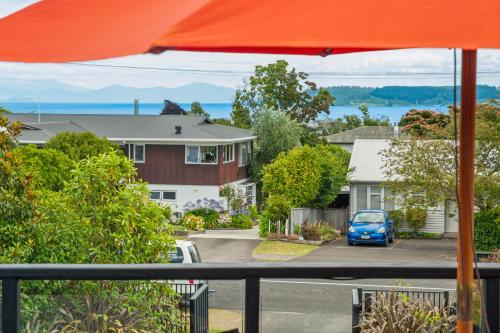 a view of a house from a balcony with an orange umbrella at Great Lake Getaway - Taupo in Taupo